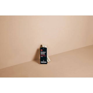 Dog chew made of red deer antler splits in a black packaging box against a beige backdrop.