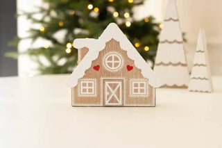 Chunky wooden cabin ornament with white snow roof and red hearts on natural wood finish