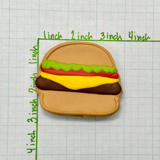 Lunch Menu hamburger cookie for dogs with brown bun, green lettuce, and yellow cheese