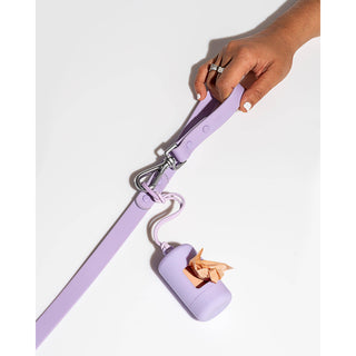 Poop bag carrier dispenser in lavender, attached to a matching leash with a metal clip.