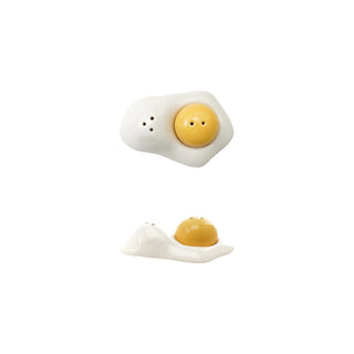 Stoneware salt and pepper shakers shaped like egg yolk and white, with a yellow yolk accent on a white base.
