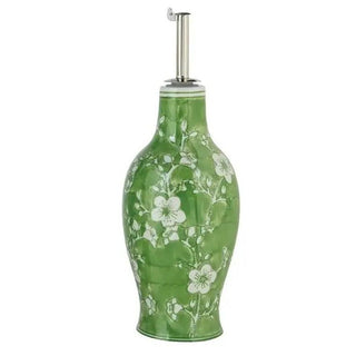 Hand-painted stoneware oil cruet with green glaze and white floral motif, metal pour spout.