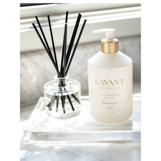 Reed diffuser Blushed Bergamot; white bottle with a gold collar, black reeds on a clear acrylic tray