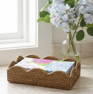 Blue hydrangea hostess gift set on a brown wicker tray with colorful napkins; vase of blue hydrangeas in the background.