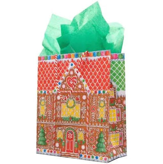 Gift bag featuring a colorful gingerbread house design with green tissue paper