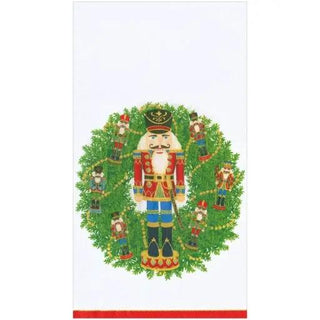 Guest towel napkin with Nutcracker wreath design featuring a central Nutcracker and surrounding figures among green foliage.