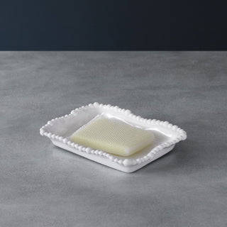 White melamine kitchen sponge holder with a beaded edge, shown with a yellow sponge.