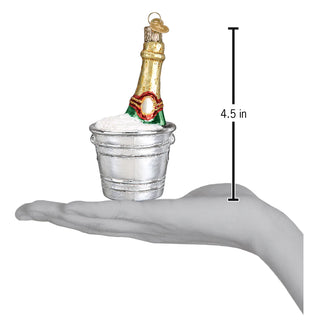 Champagne bottle ornament in a silver ice bucket with snow accents