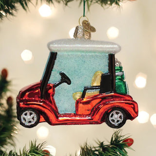 Glass golf cart ornament in red with white roof, black wheels and a golf bag in back, holiday decoration.